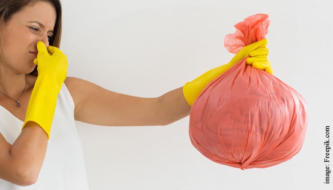 A woman holding a bag full of trash